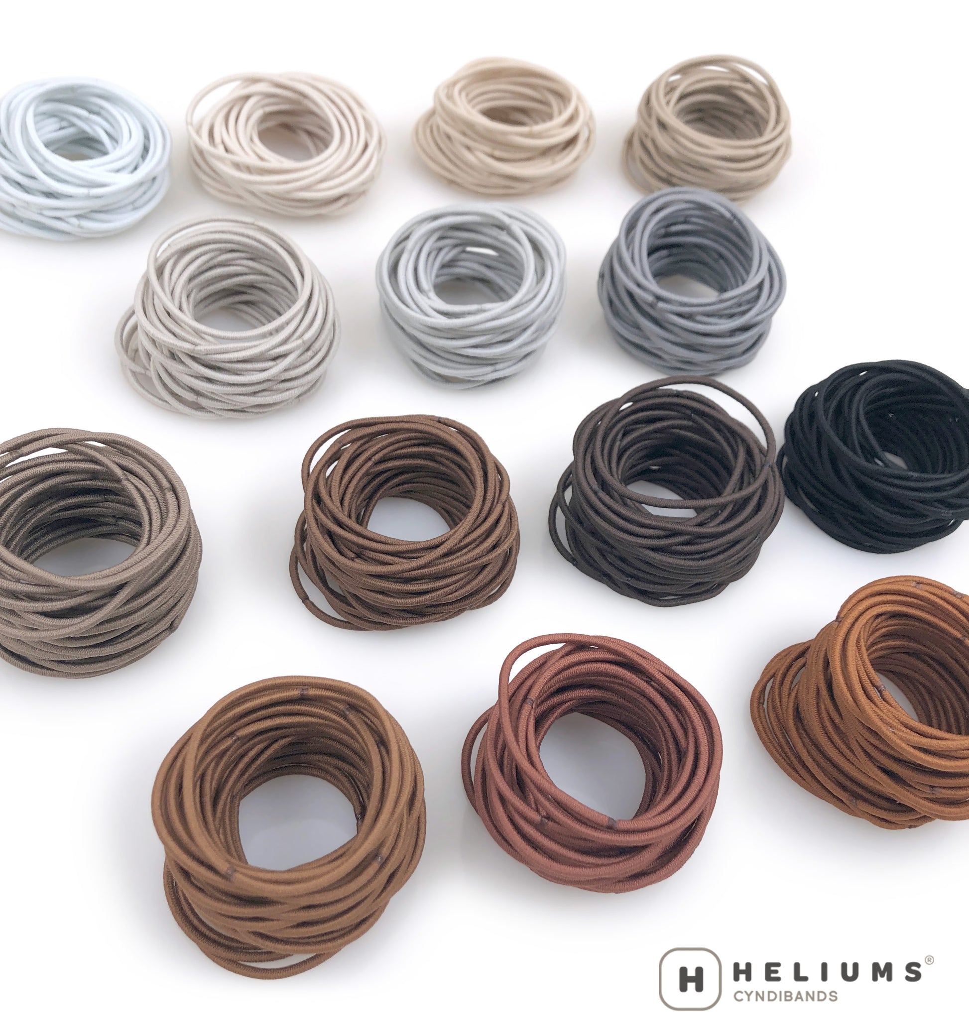 Stacks of Heliums thin hair ties in 14 neutral shades