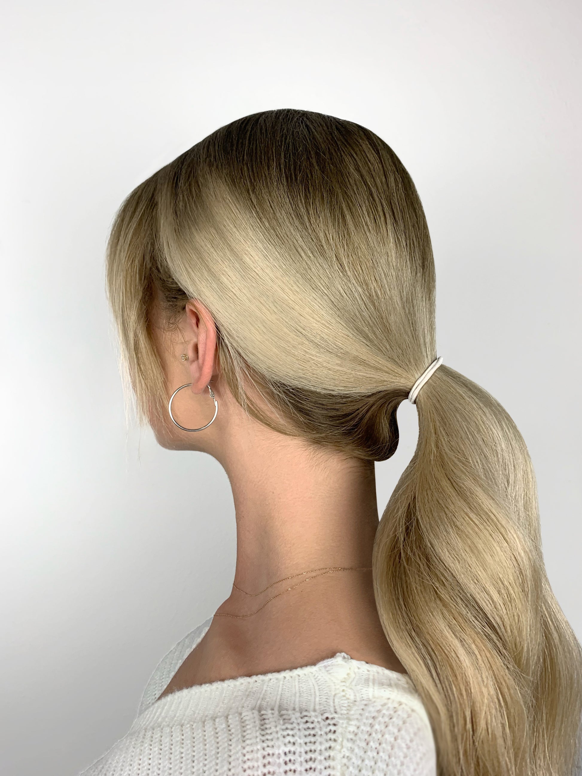 Blonde woman wearing low ponytail and Heliums 2mm thin hair elastic
