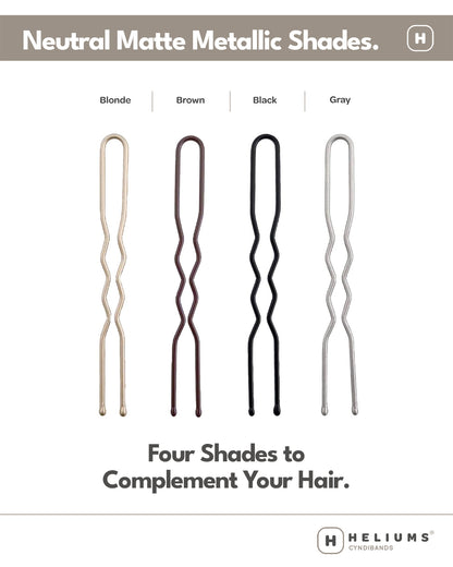 Heliums hair pins in four neutral matte metallic shades: Blonde, Brown, Black, and Gray. The image shows four wavy double-prong hair pins in different colors (gold, bronze, black, and silver) on a white background with descriptive text.