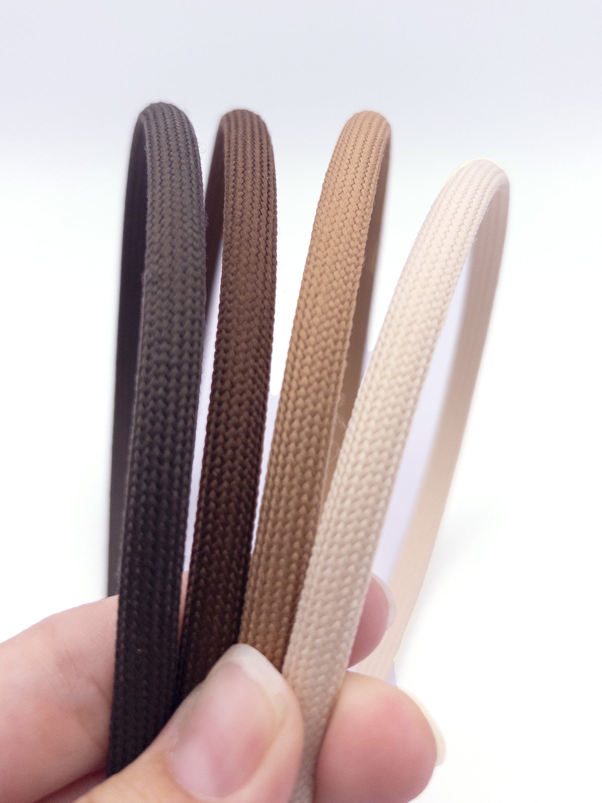 close up view of 4 headbands in neutral brown and off white shades