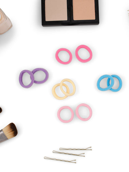 Heliums Small Seamless Hair Ties shown in multiple colors next to bobby pins and makeup