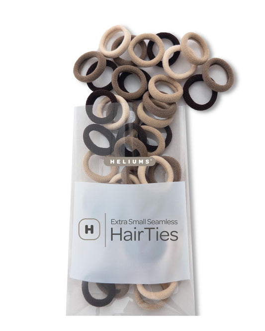 Pack of Heliums Extra Small Seamless Hair Ties in various neutral colors on a white background