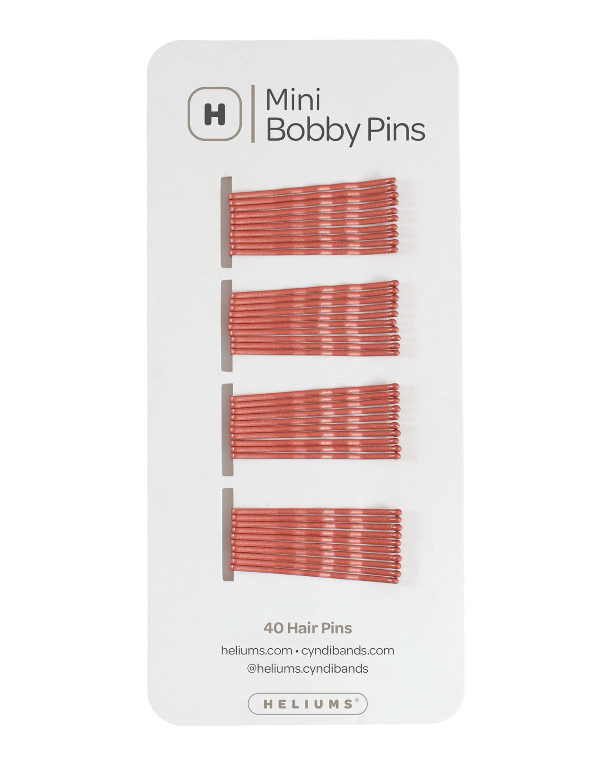 Heliums mini bobby pins in a auburn red hue, packaged on a white card with the Heliums logo at the top.