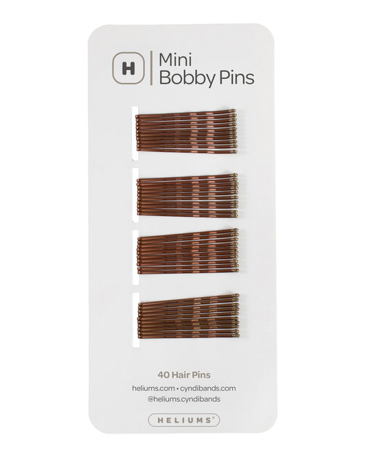 Heliums mini hair pins in brown shades, displayed on a white backing card with the Heliums brand logo.