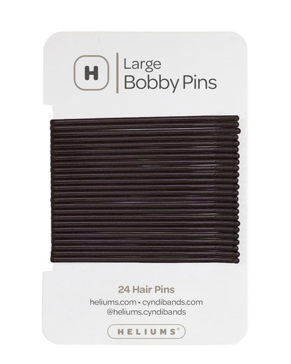 Heliums Cyndibands hair pins in a pack of 24, displayed on their white retail backing card. The pins are a very dark, near-black, and the packaging clearly displays the brand name 'Heliums' and product type.