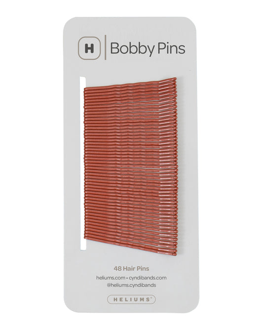 Packaging of Heliums brand 2-inch wavy auburn color bobby pins, displaying multiple pins on white card with the brand logo and name.